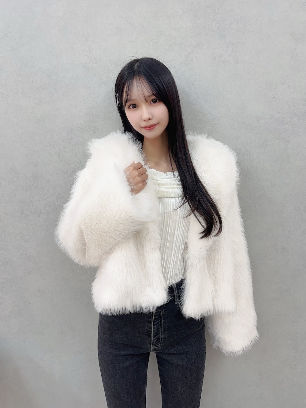 ホワイト系のその他アウター、ブラック系のデニムパンツ、ホワイト系のTシャツ/カットソーを着用したレディースの冬コーディネートの5枚目の写真