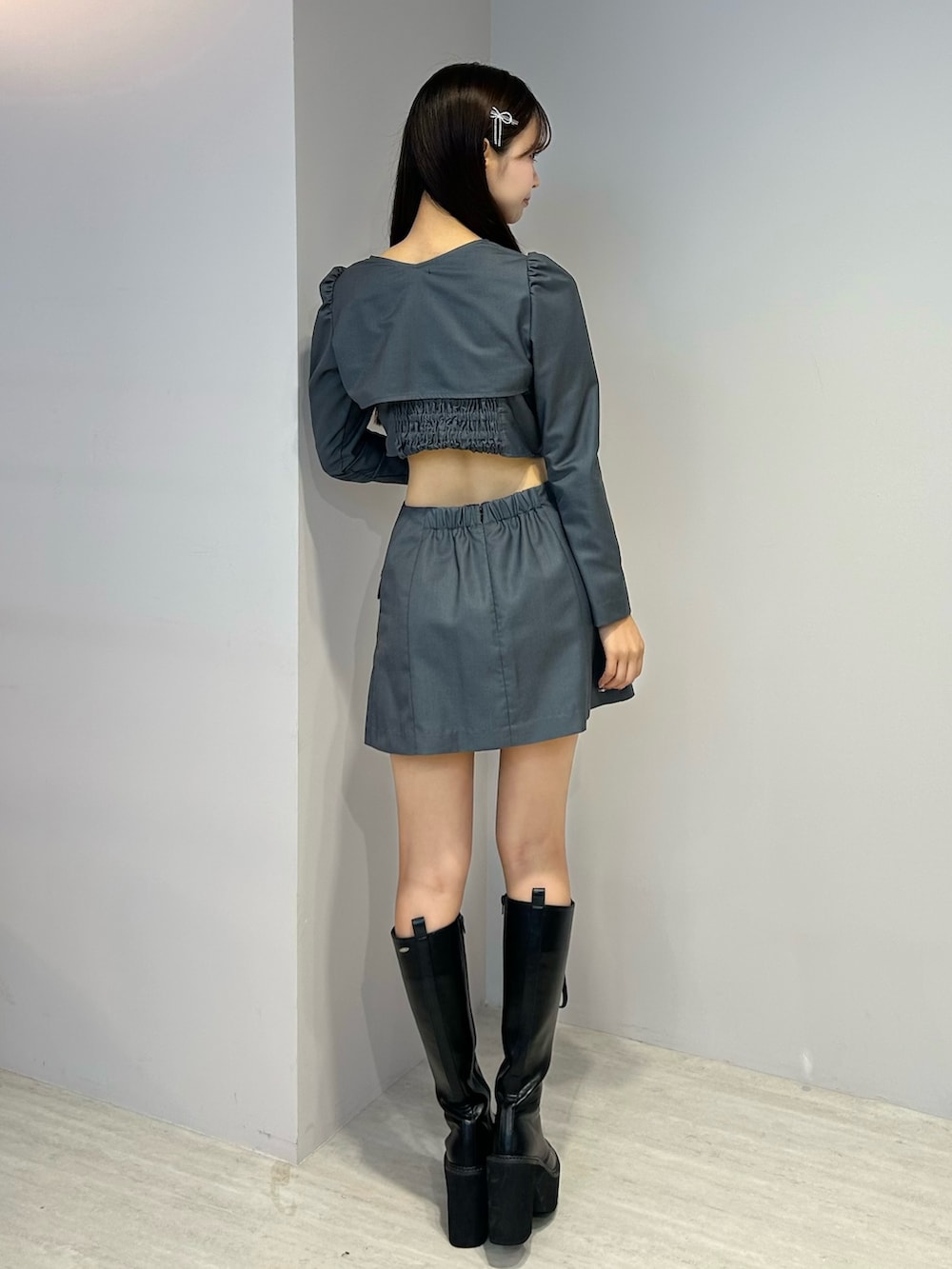 グレー系のワンピース、ブラック系のブーツ、シルバー系のヘアピンを着用したレディースの秋コーディネートの3枚目の写真