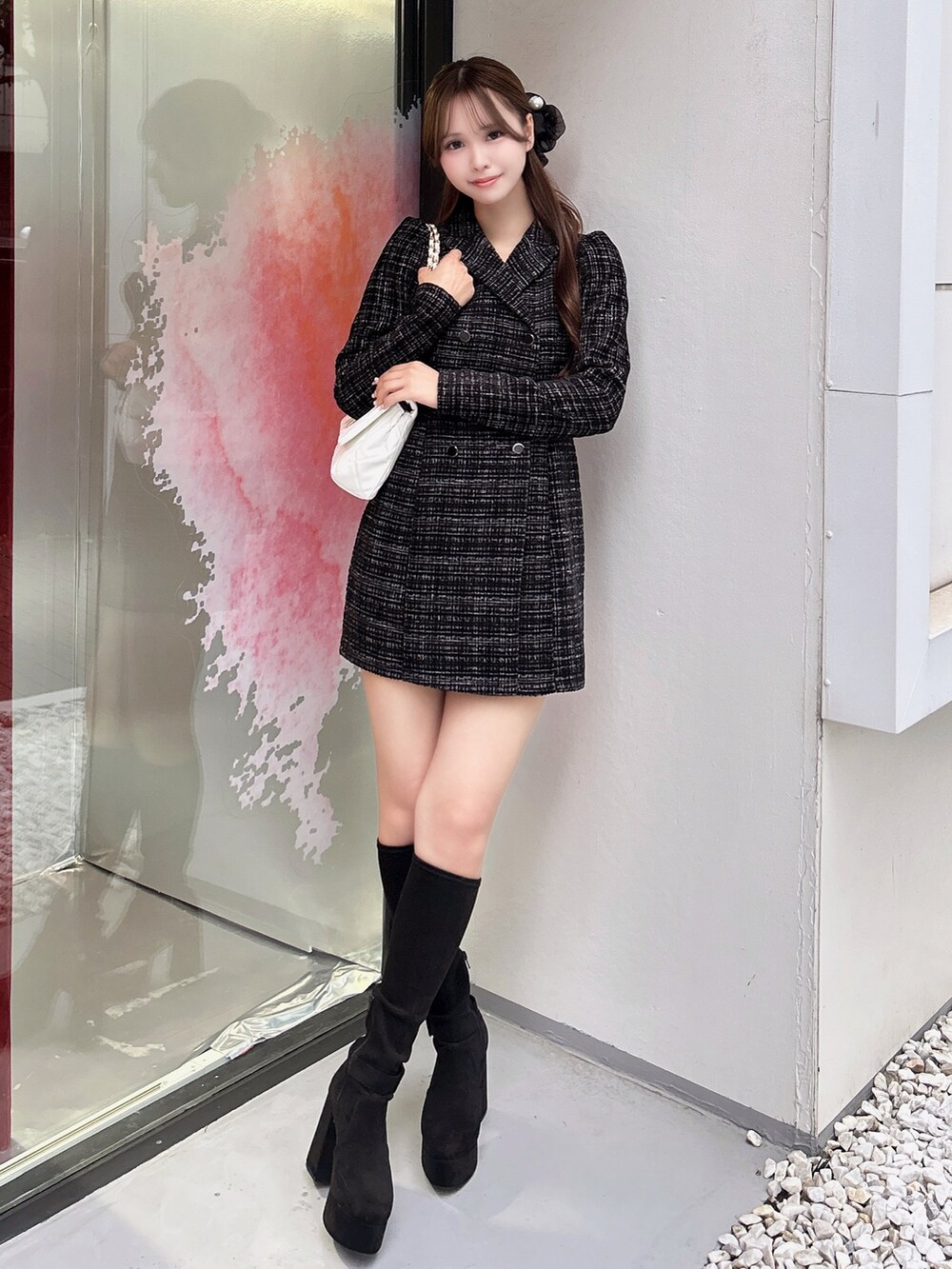 ブラック系のワンピース、ホワイト系のハンドバッグ、ブラック系のブーツを着用したレディースの秋コーディネートの2枚目の写真