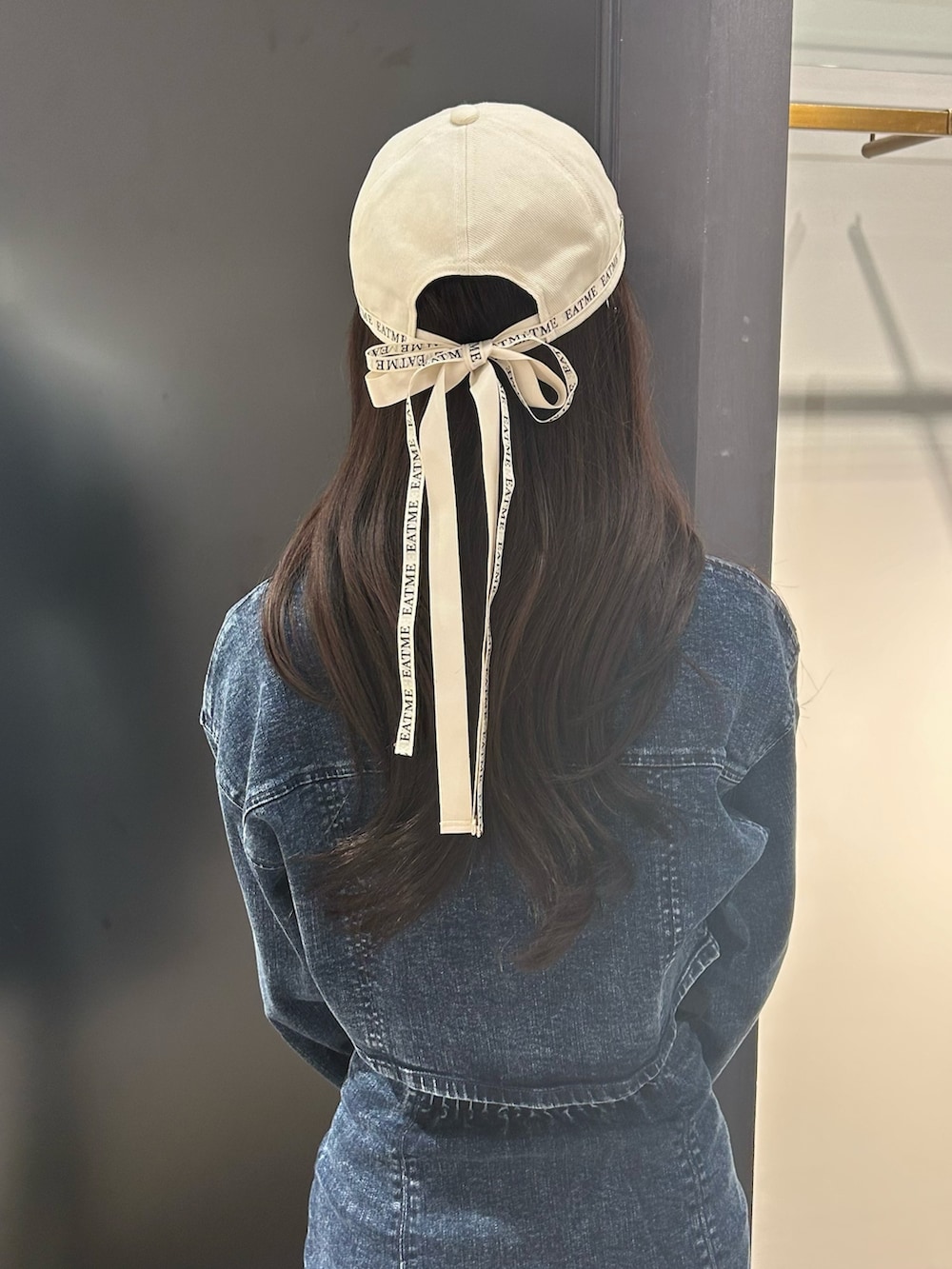 ブルー系のデニムジャケット、ブラック系のTシャツ/カットソー、ブルー系のデニムスカートを着用したレディースの冬コーディネートの2枚目の写真