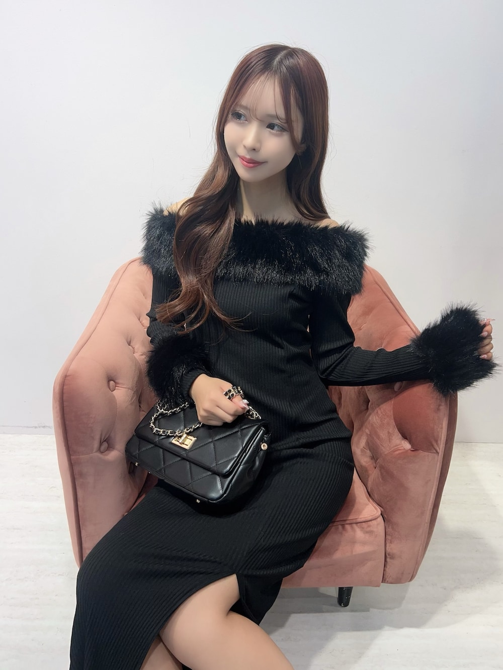 ブラック系のワンピース、ブラック系のブーツ、ブラック系のハンドバッグを着用したレディースの秋コーディネートの5枚目の写真