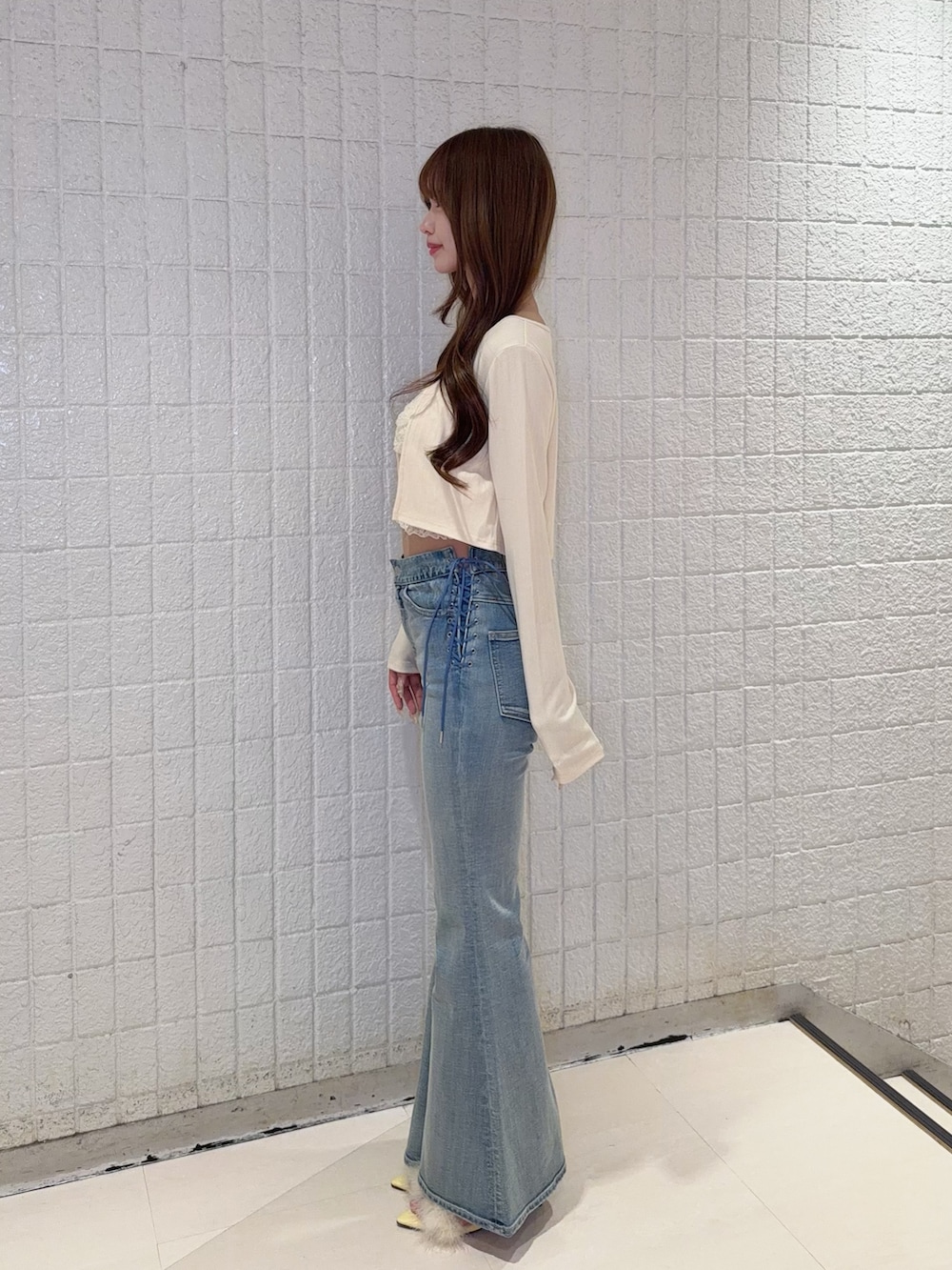 イエロー系のTシャツ/カットソー、ブルー系のデニムパンツ、イエロー系のサンダルを着用したレディースの春コーディネートの3枚目の写真