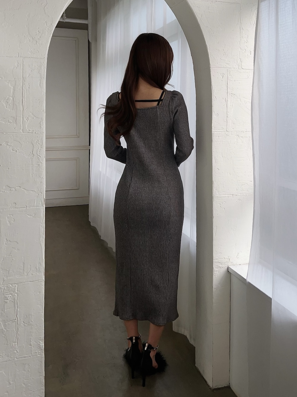 グレー系のワンピース、ブラック系のサンダルを着用したレディースの冬コーディネートの4枚目の写真