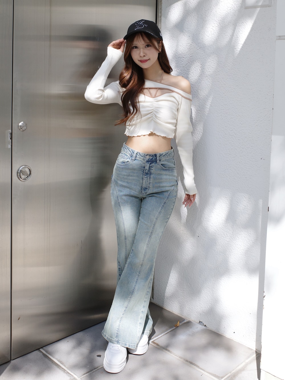 ブルー系のデニムパンツ、ホワイト系のTシャツ/カットソー、ブラック系のキャップを着用したレディースの冬コーディネートの2枚目の写真