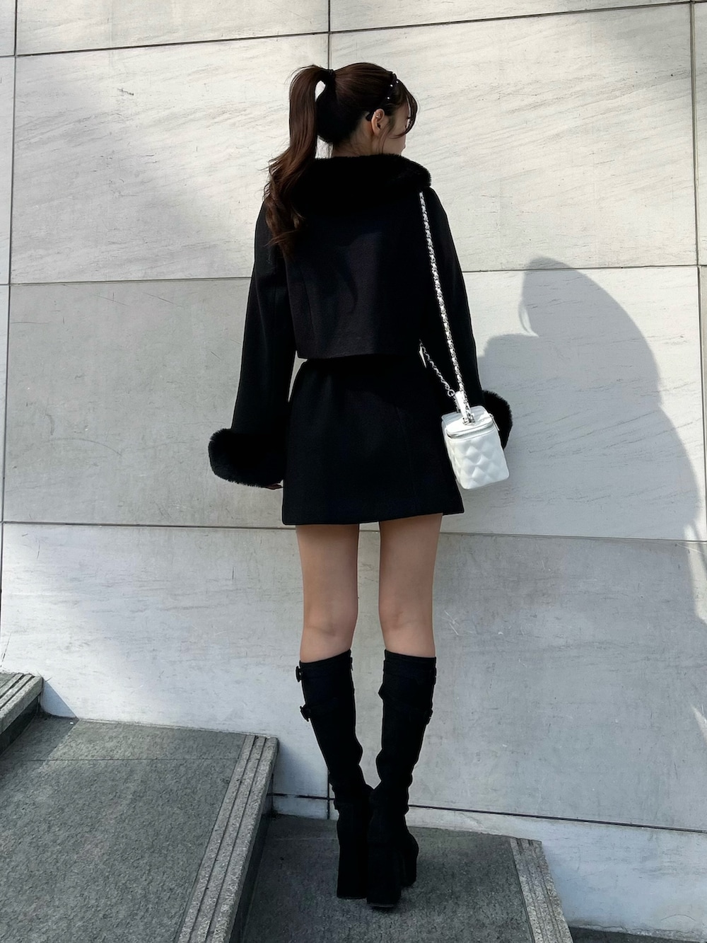 ブラック系のその他アウター、ブラック系のスカート、ブラック系のブーツを着用したレディースの秋コーディネートの4枚目の写真