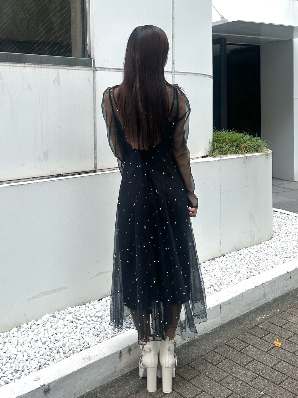 ブラック系のワンピース、ホワイト系のブーツを着用したレディースの秋コーディネートの4枚目の写真