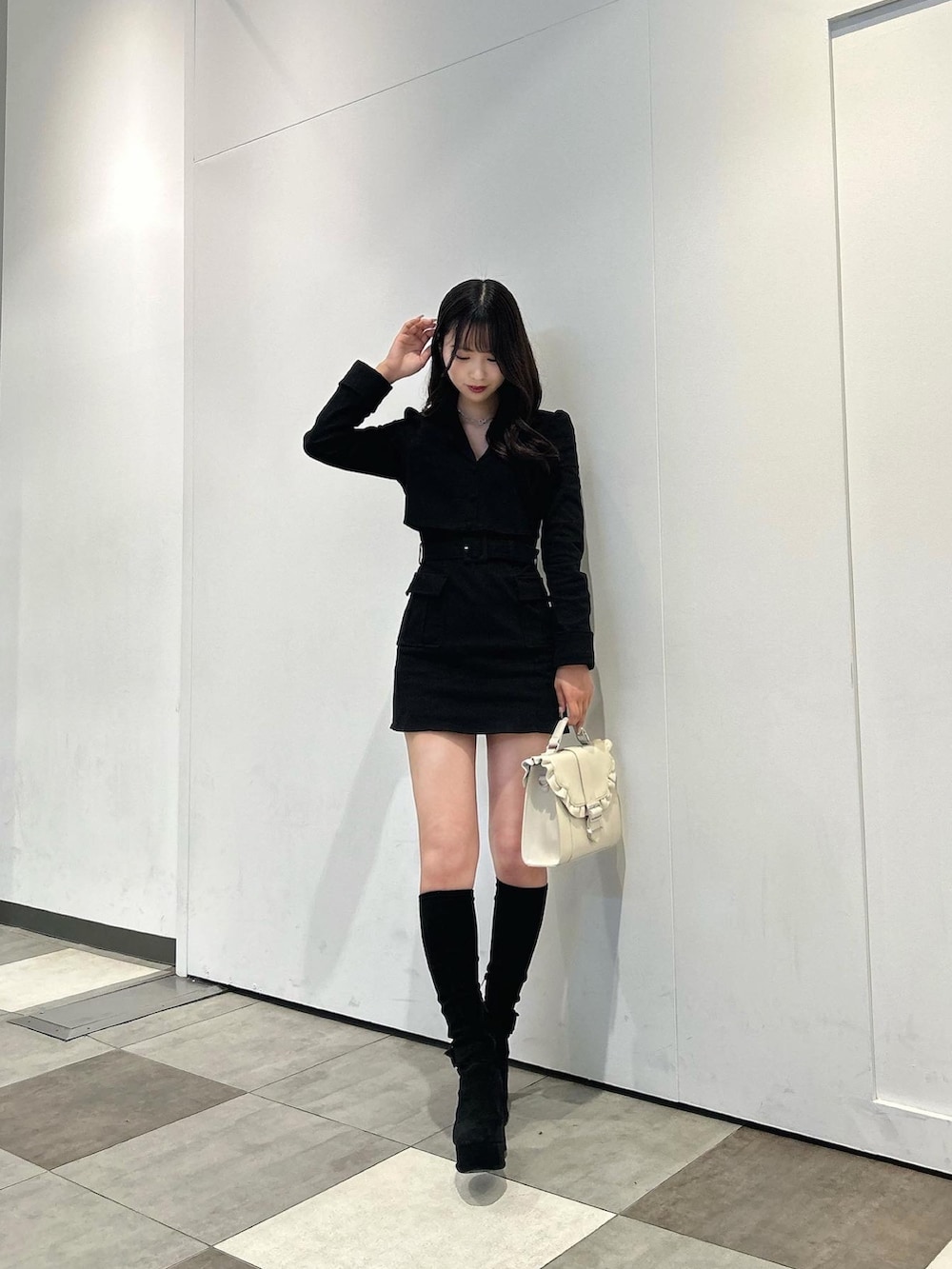 ブラック系のブーツ、ベージュ系のショルダーバッグ、ブラック系のワンピースを着用したレディースの冬コーディネートの3枚目の写真