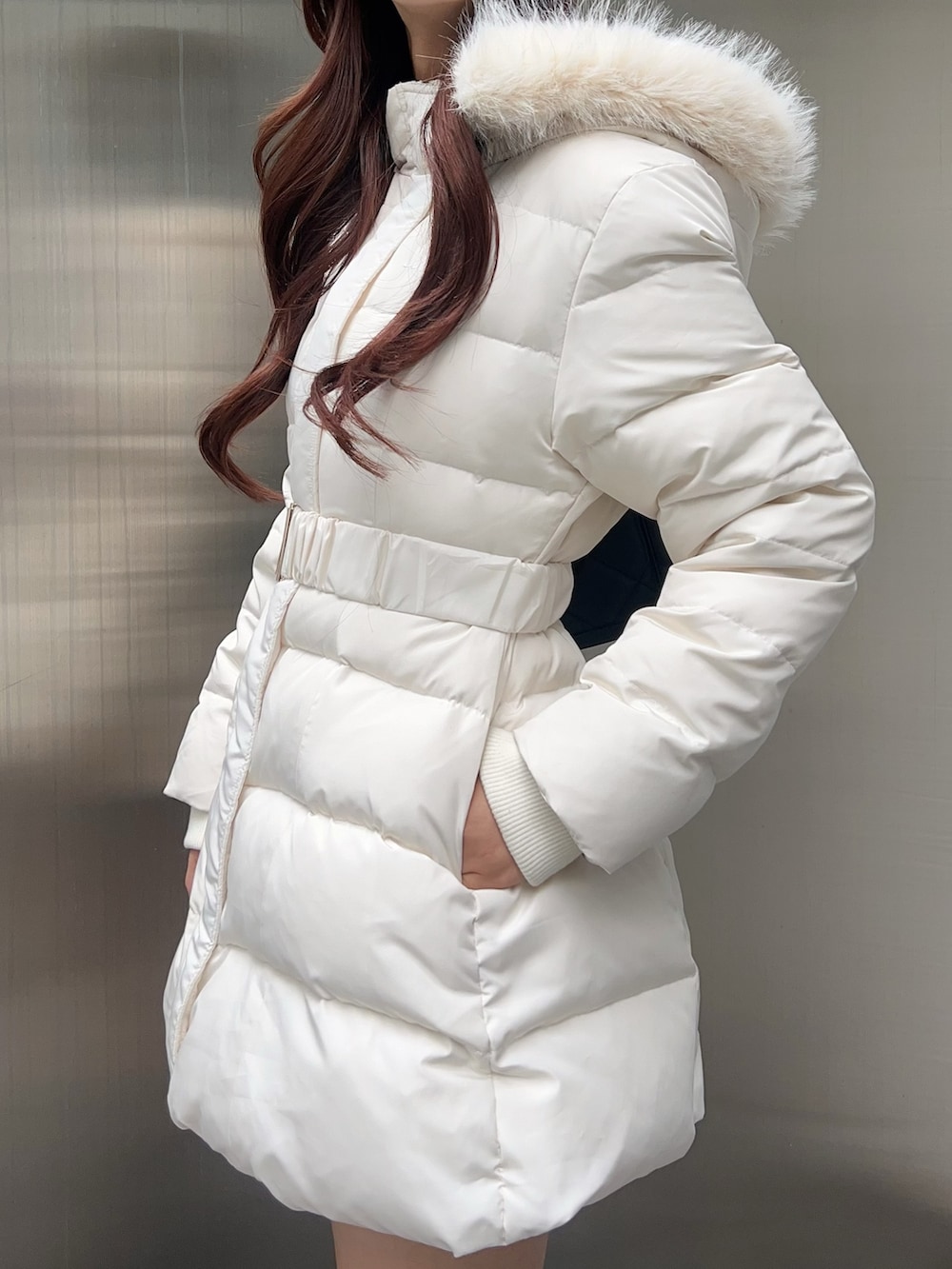 ホワイト系のダウンジャケット/コート、ブラック系のブーツ、ブラック系のハンドバッグを着用したレディースの秋コーディネートの6枚目の写真