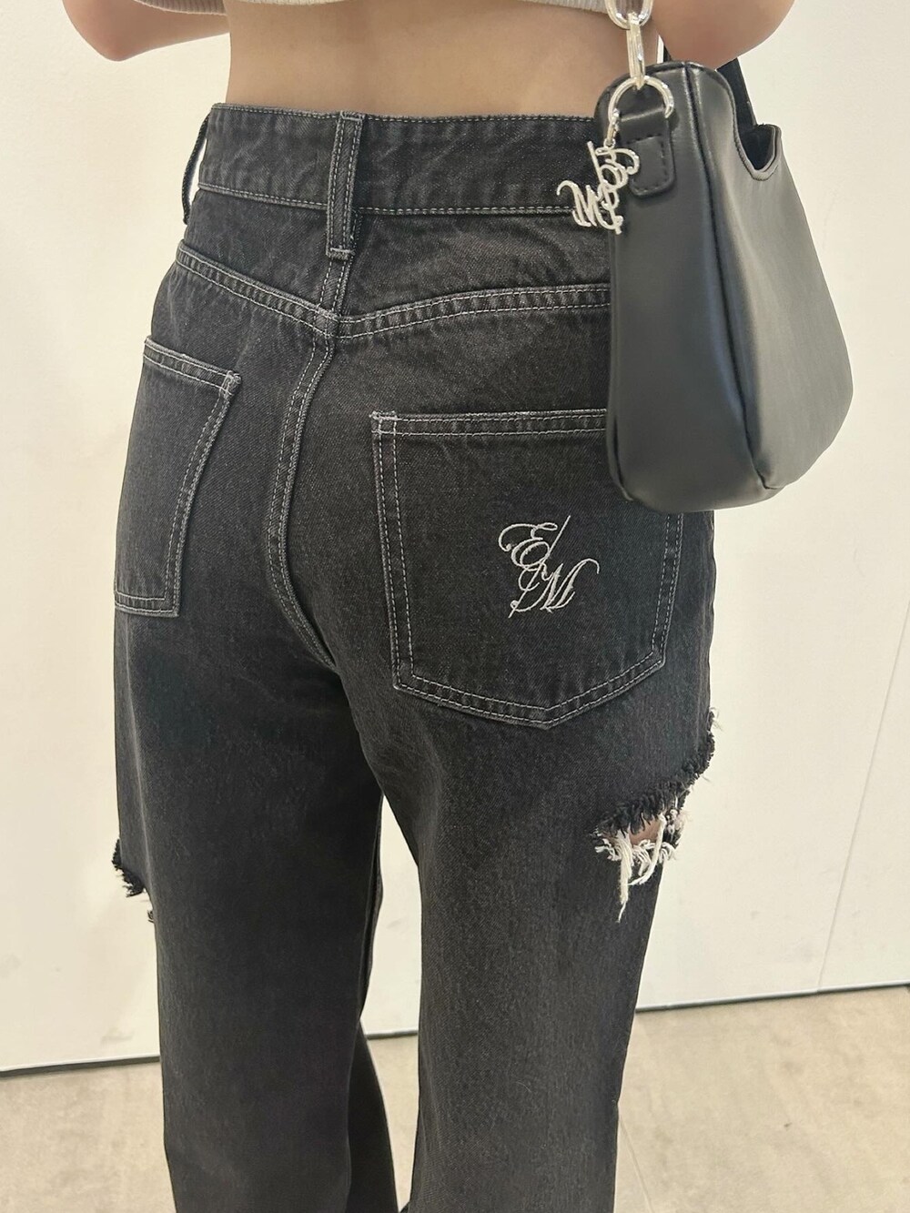 ブラック系のデニムパンツ、ブラック系のショルダーバッグ、ブラック系のサンダルを着用したレディースの春コーディネートの5枚目の写真