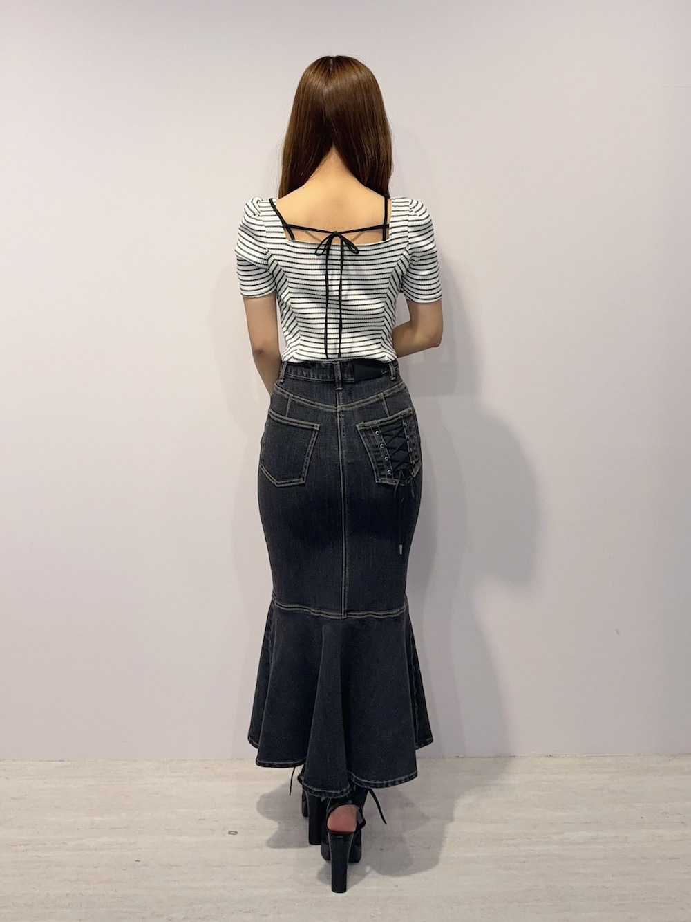 ブラック系のデニムスカート、その他のTシャツ/カットソー、ブラック系のサンダルを着用したレディースの春コーディネートの4枚目の写真