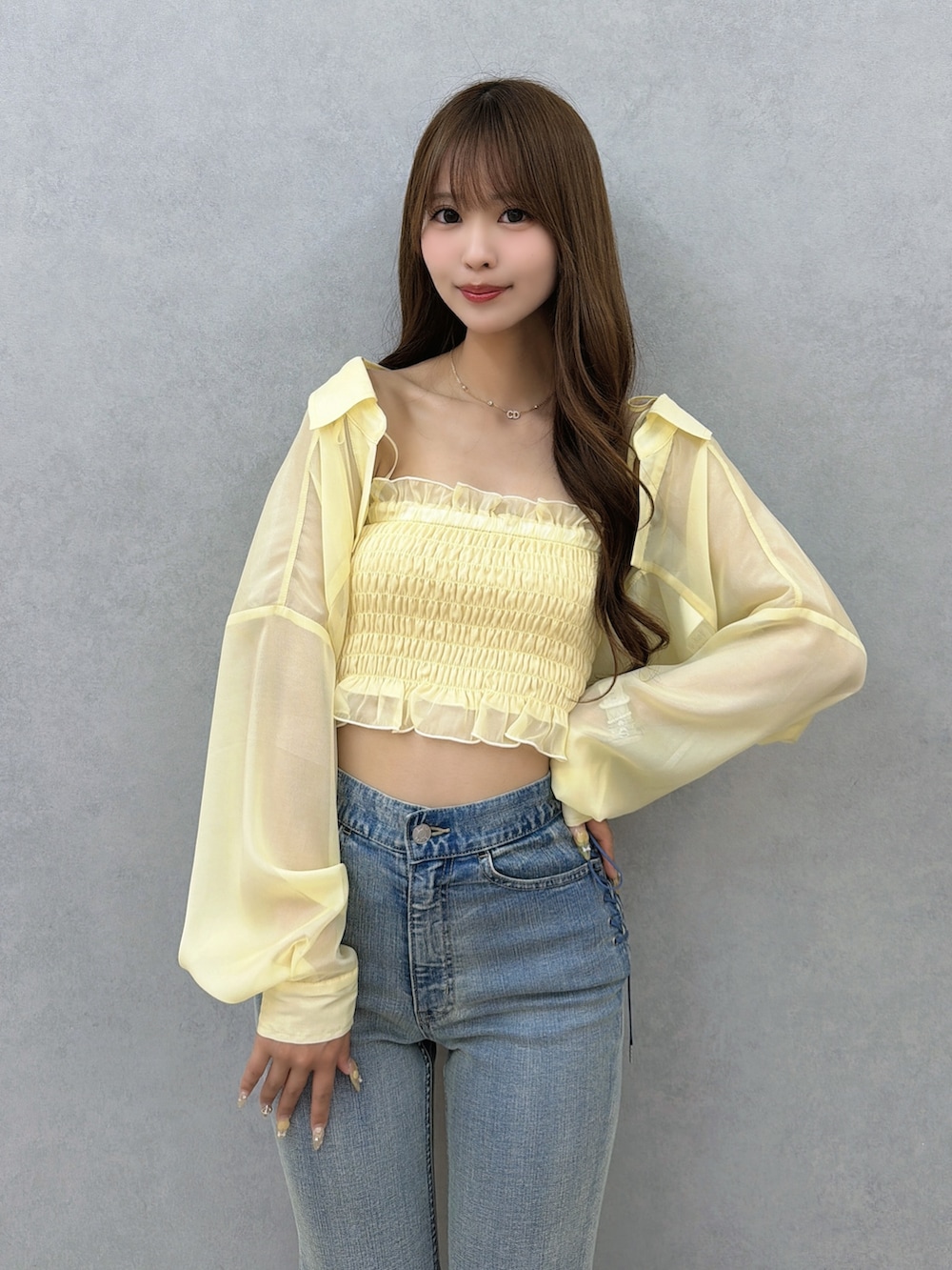 ブルー系のデニムパンツ、イエロー系のシャツ/ブラウス、ホワイト系のサンダルを着用したレディースの春コーディネートの5枚目の写真