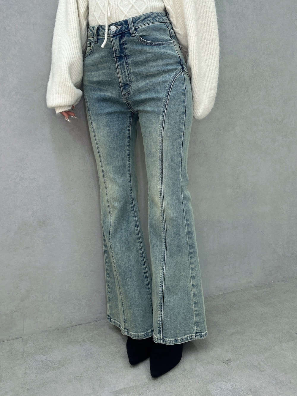 ブルー系のデニムパンツ、ホワイト系のニット/セーター、ブラック系のブーツを着用したレディースの冬コーディネートの7枚目の写真