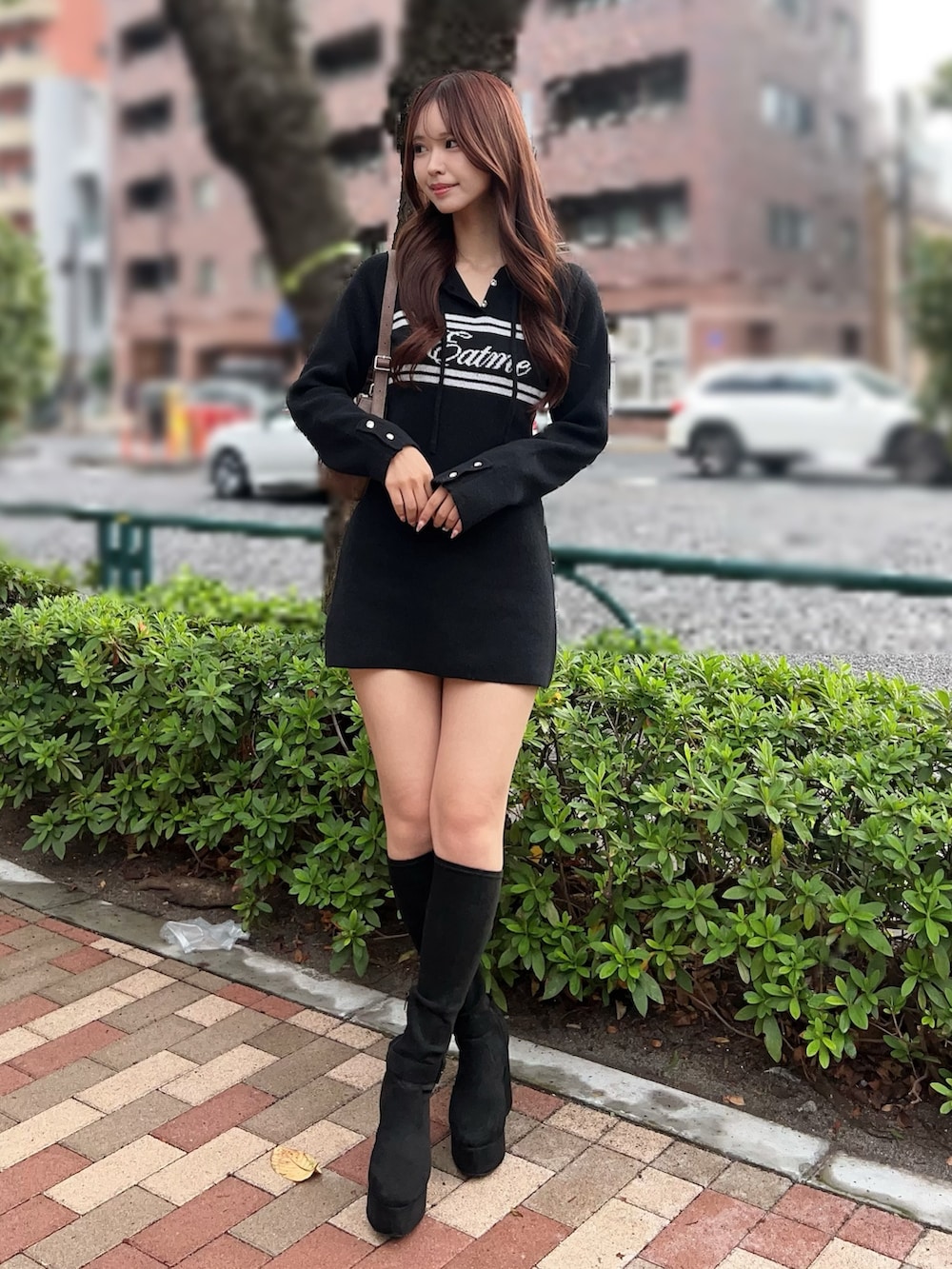 ブラック系のブーツ、ブラック系のワンピース、ブラウン系のショルダーバッグを着用したレディースの秋コーディネートの2枚目の写真