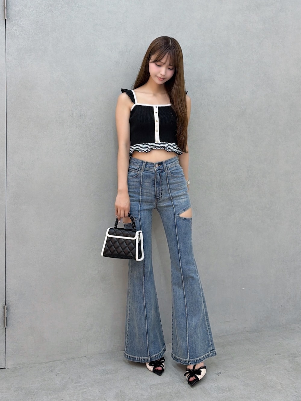ブルー系のデニムパンツ、ブラック系のキャミソールを着用したレディースの夏コーディネートの2枚目の写真