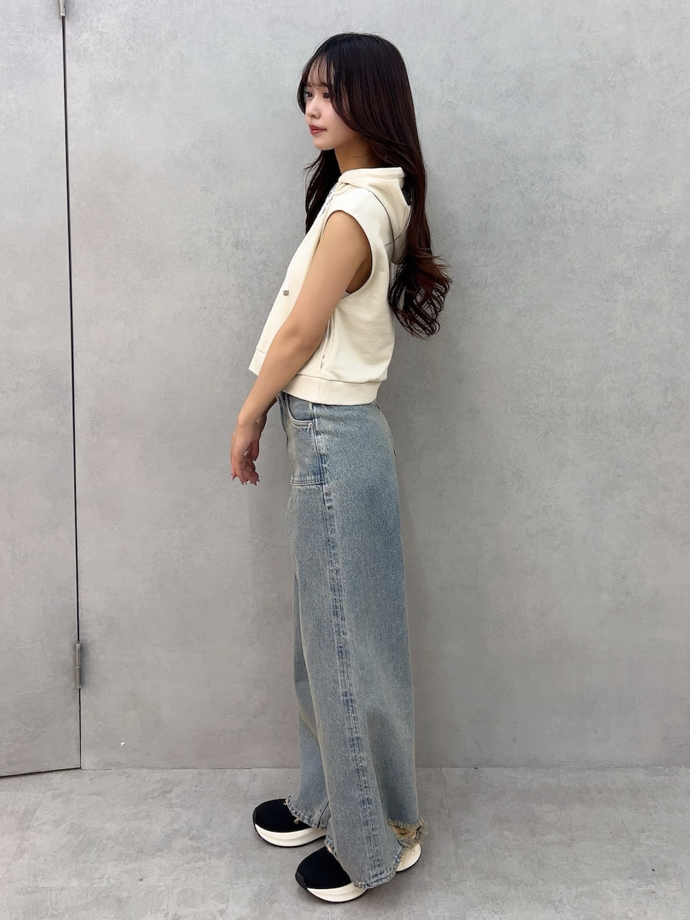 ブルー系のデニムパンツ、ホワイト系のTシャツ/カットソー、ブラック系のブーツを着用したレディースの冬コーディネートの2枚目の写真