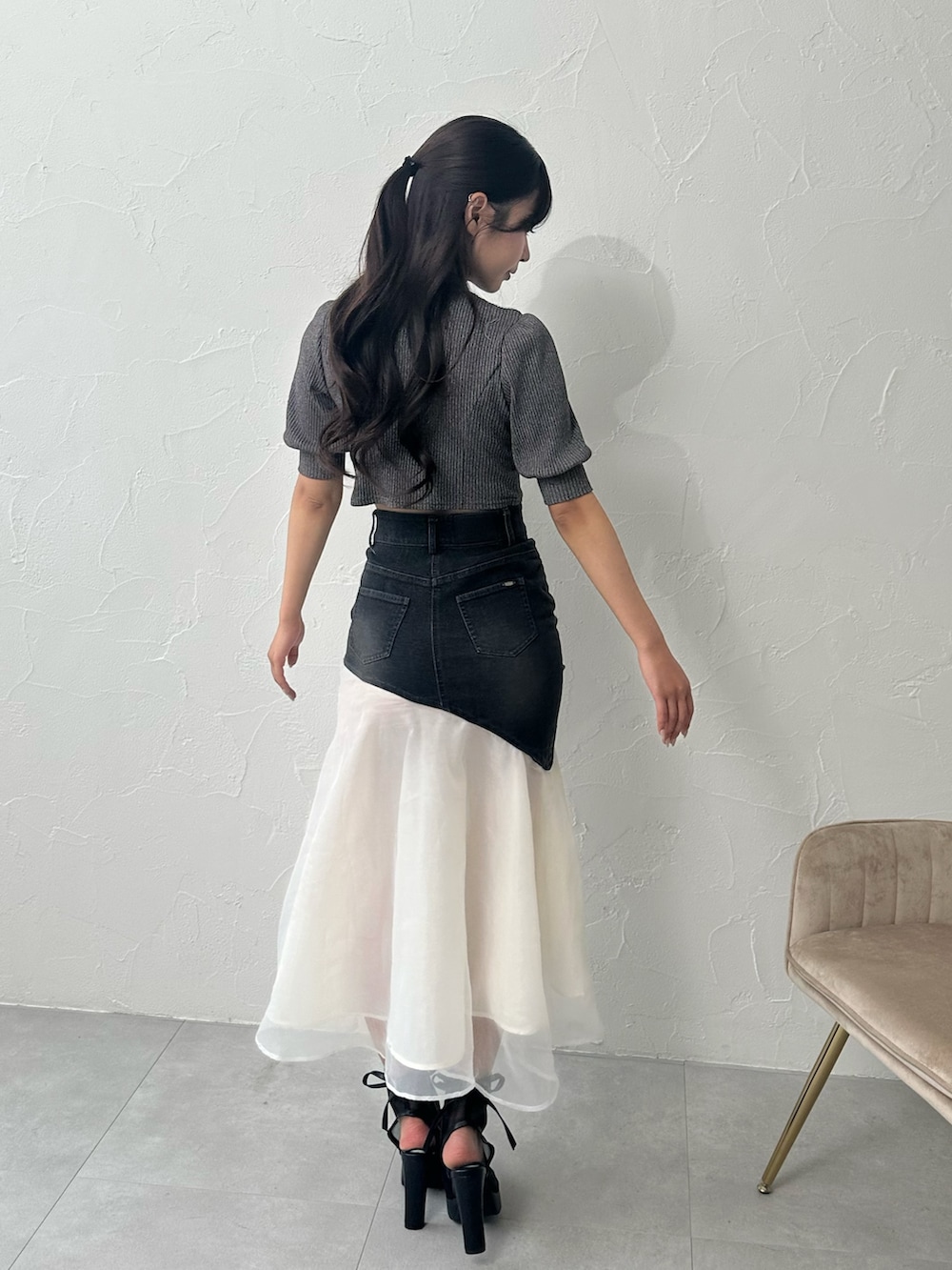 ブラック系のデニムスカート、グレー系のTシャツ/カットソー、ブラック系のサンダルを着用したレディースの夏コーディネートの3枚目の写真