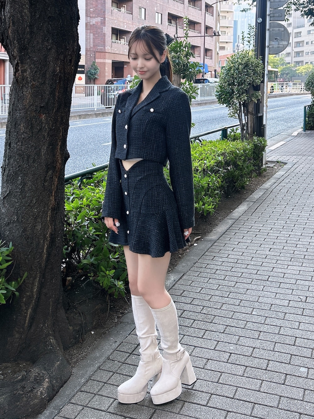 ブラック系のスカート、ブラック系のテーラードジャケット、ホワイト系のブーツを着用したレディースの秋コーディネートの2枚目の写真