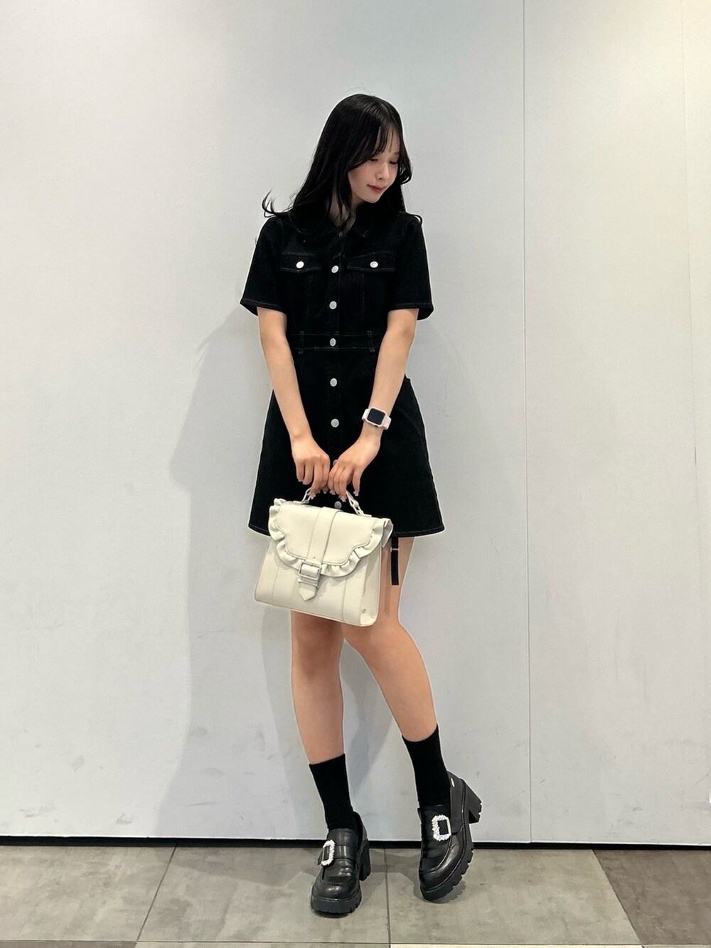 ブラック系のワンピース、ブラック系のローファー、ベージュ系のショルダーバッグを着用したレディースの春コーディネートの3枚目の写真