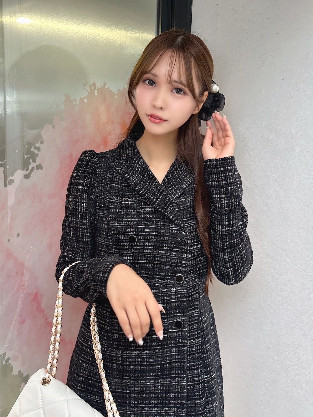 ブラック系のワンピース、ホワイト系のハンドバッグ、ブラック系のブーツを着用したレディースの秋コーディネートの9枚目の写真