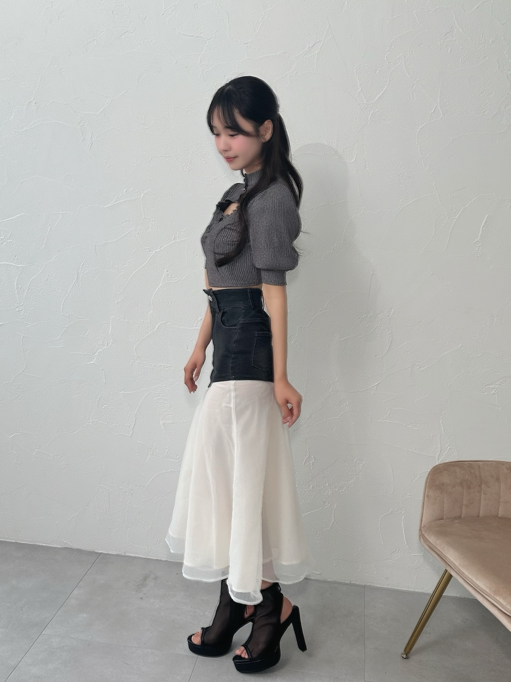 ブラック系のデニムスカート、グレー系のTシャツ/カットソー、ブラック系のサンダルを着用したレディースの夏コーディネートの2枚目の写真