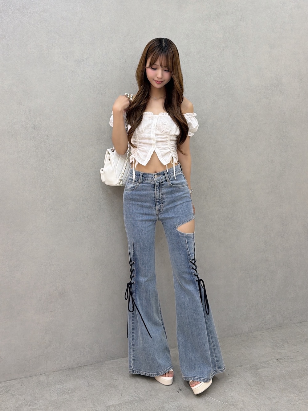 ブルー系のデニムパンツ、ホワイト系のシャツ/ブラウス、ホワイト系のバックパック/リュックを着用したレディースの夏コーディネートの2枚目の写真