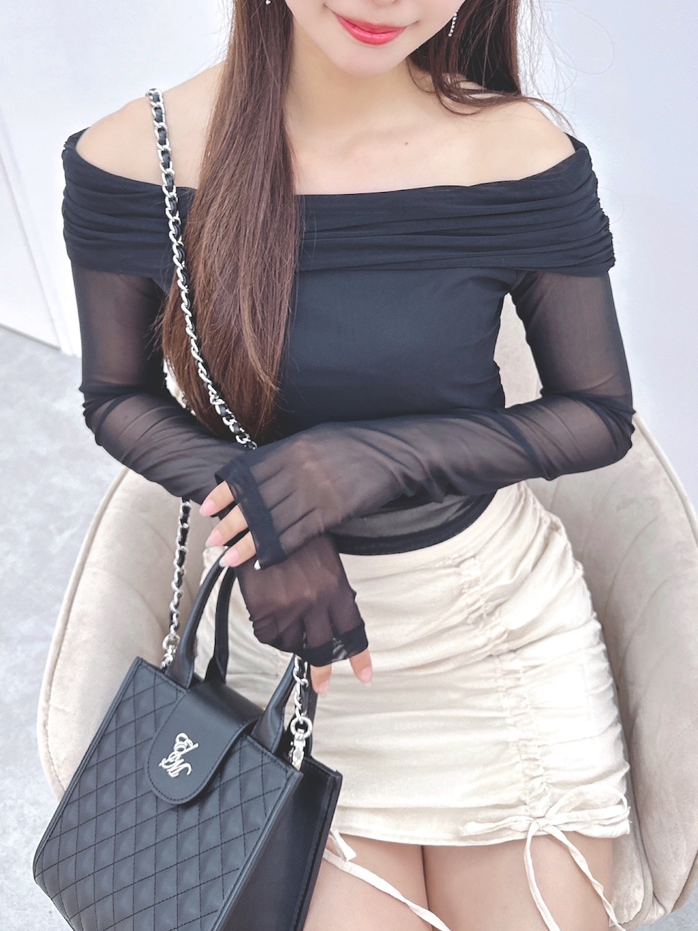 ホワイト系のスカート、ブラック系のTシャツ/カットソー、ホワイト系のサンダルを着用したレディースの春コーディネートの4枚目の写真