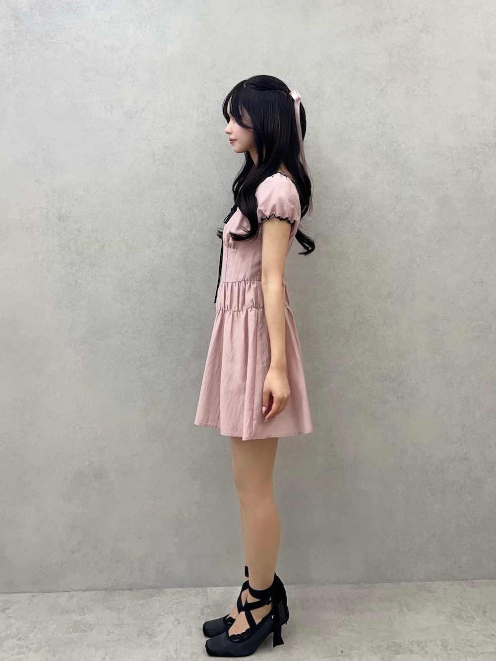 ピンク系のワンピース、ブラック系のパンプスを着用したレディースの冬コーディネートの6枚目の写真