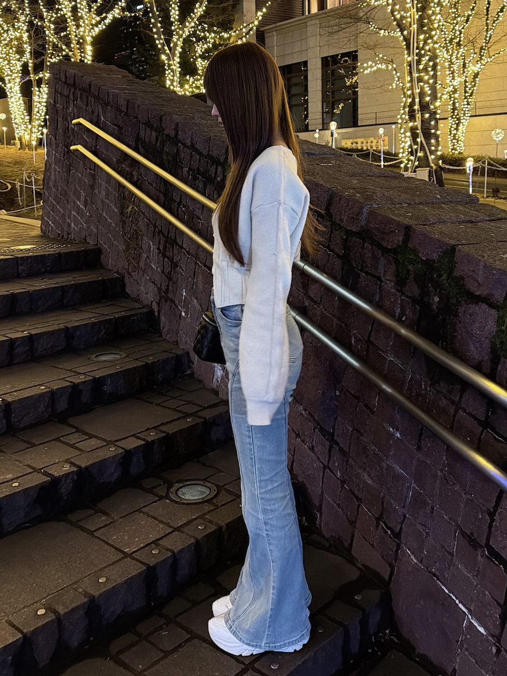 イエロー系のニット/セーター、ブルー系のデニムパンツを着用したレディースの冬コーディネートの3枚目の写真