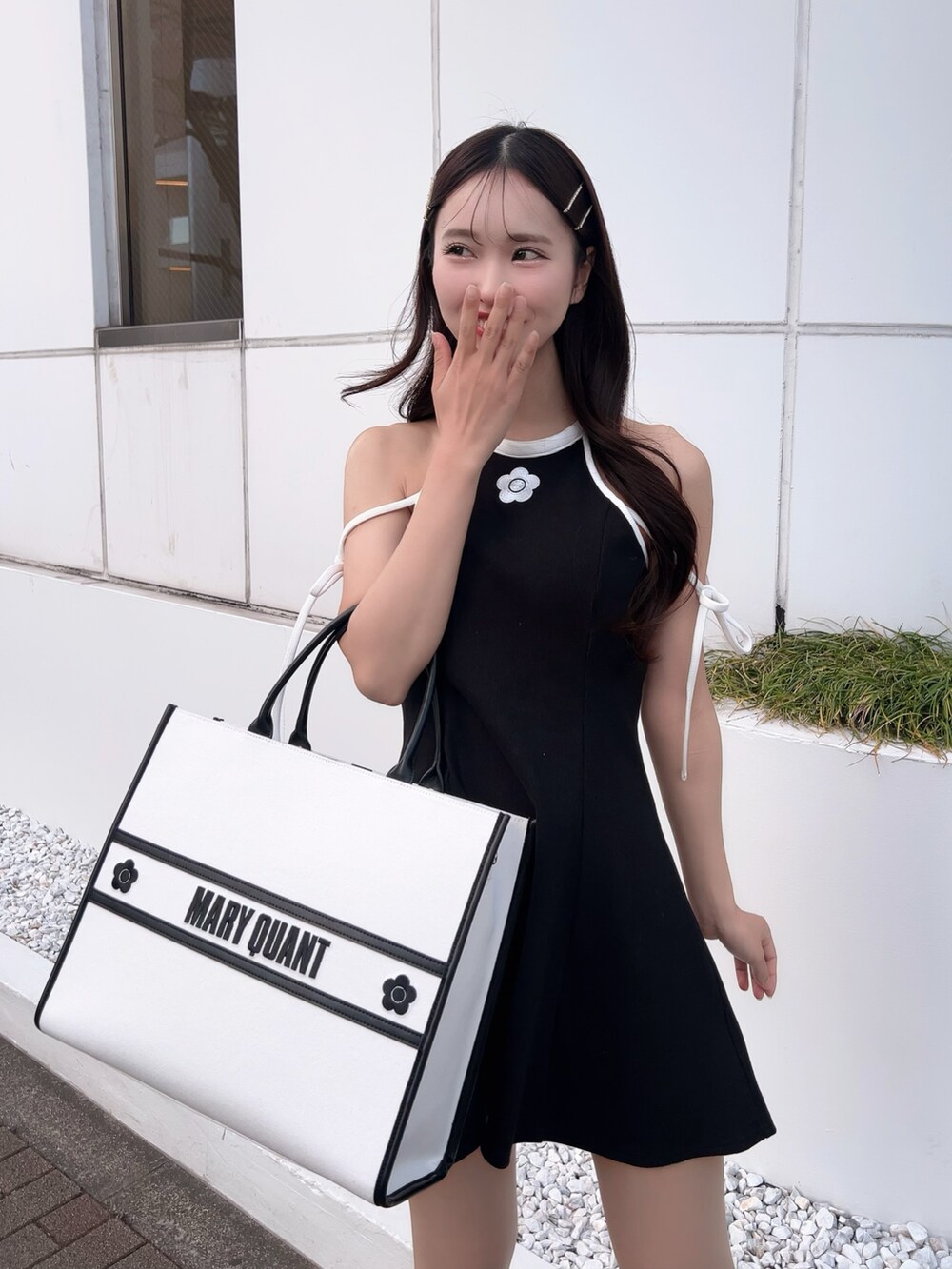 ブラック系のワンピース、ホワイト系のトートバッグ、ブラック系のサンダルを着用したレディースの春コーディネートの6枚目の写真