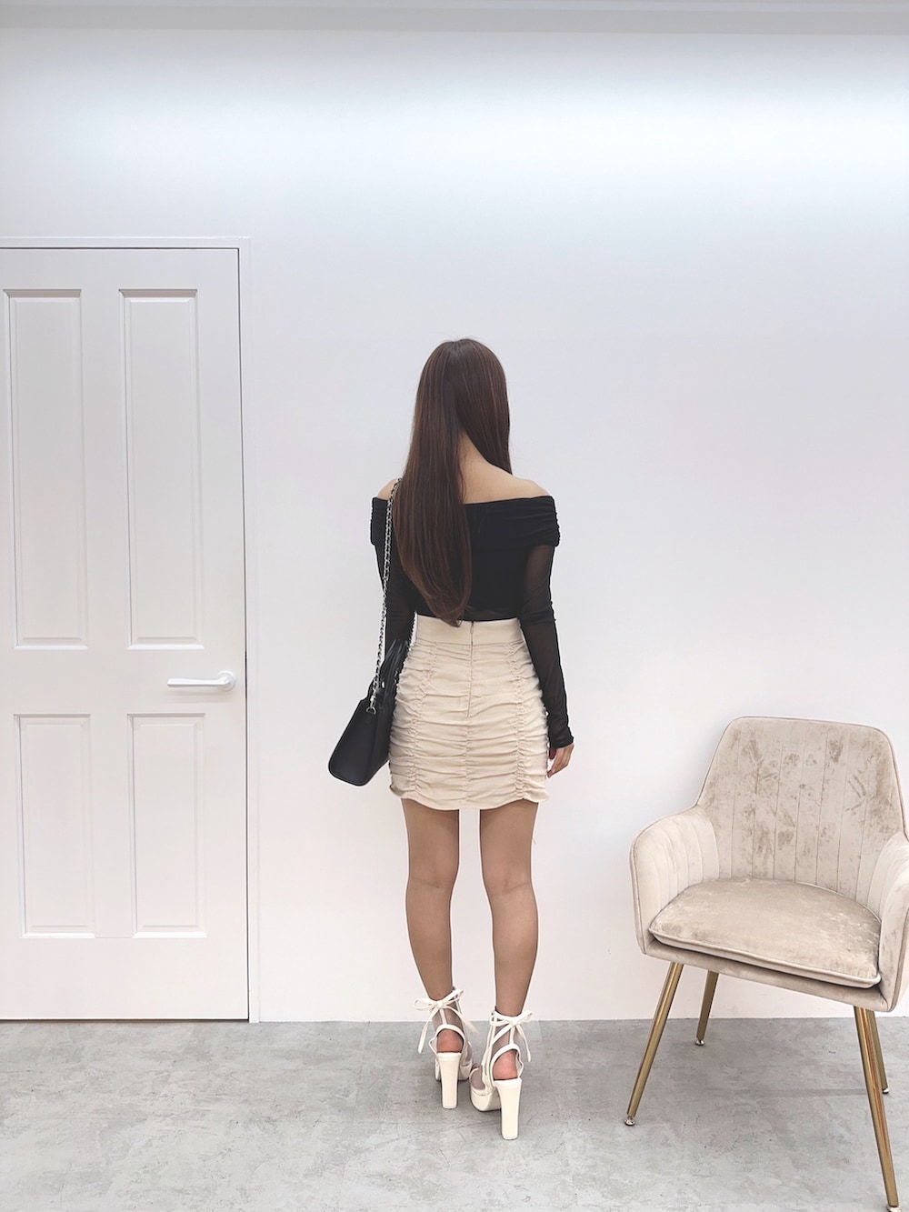 ホワイト系のスカート、ブラック系のTシャツ/カットソー、ホワイト系のサンダルを着用したレディースの春コーディネートの3枚目の写真