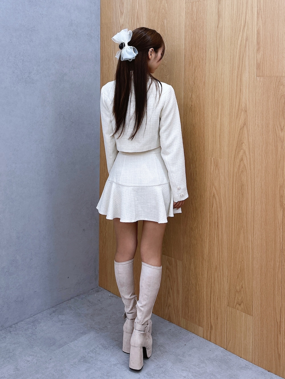 ホワイト系のスカート、ホワイト系のテーラードジャケット、ホワイト系のブーツを着用したレディースの秋コーディネートの4枚目の写真