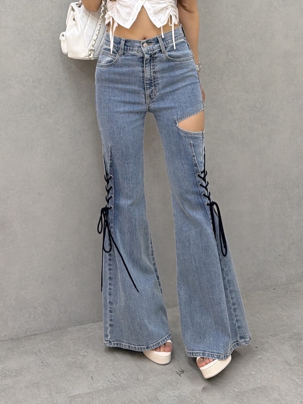 ブルー系のデニムパンツ、ホワイト系のシャツ/ブラウス、ホワイト系のバックパック/リュックを着用したレディースの夏コーディネートの6枚目の写真