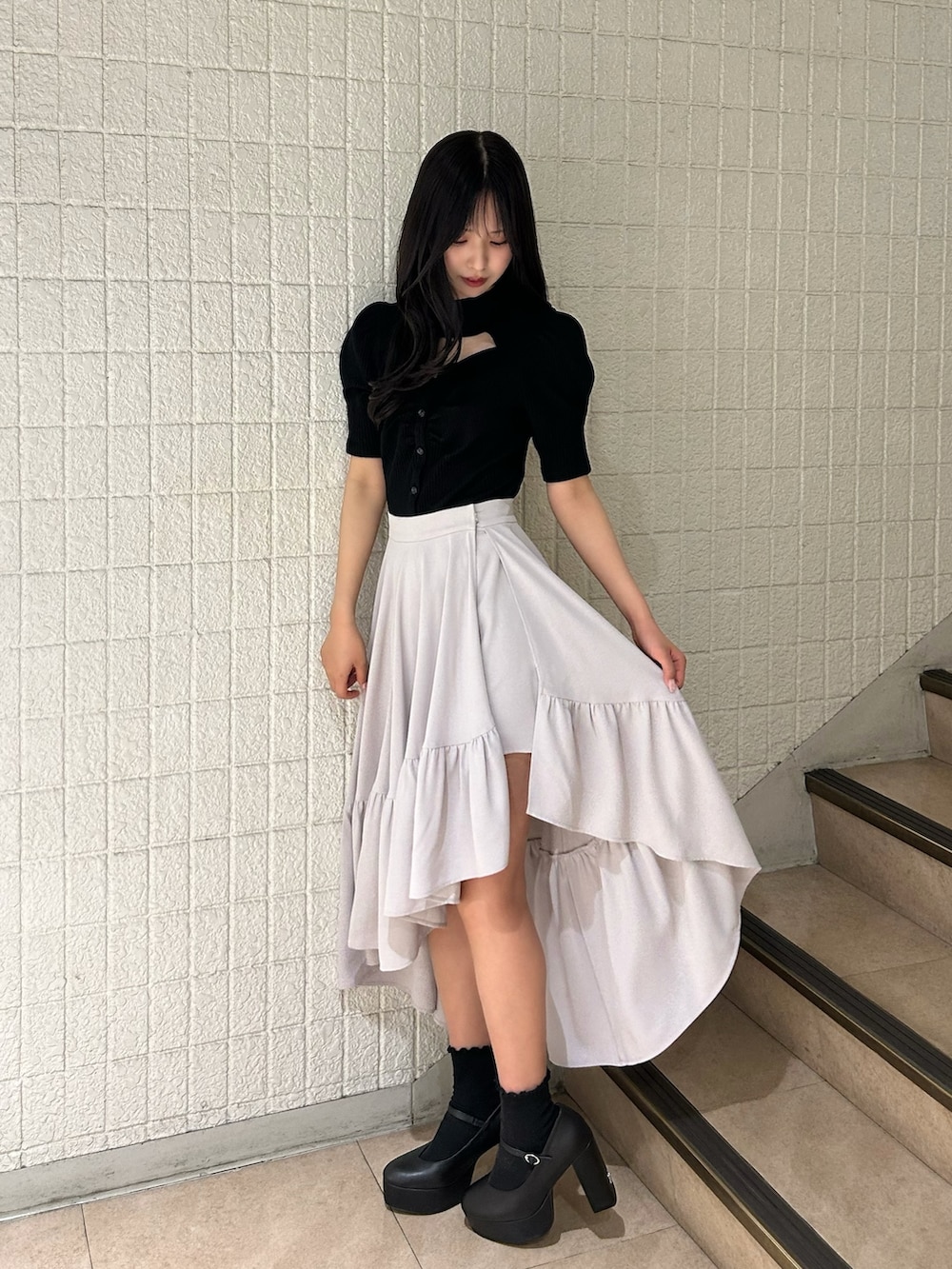 ブラック系のTシャツ/カットソー、グレー系のスカート、ブラック系のパンプスを着用したレディースの春コーディネートの3枚目の写真