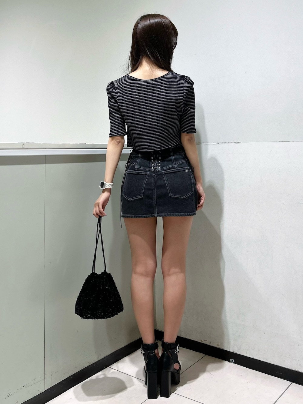 ブラック系のTシャツ/カットソー、ブラック系のデニムスカート、ブラック系のハンドバッグを着用したレディースの夏コーディネートの3枚目の写真