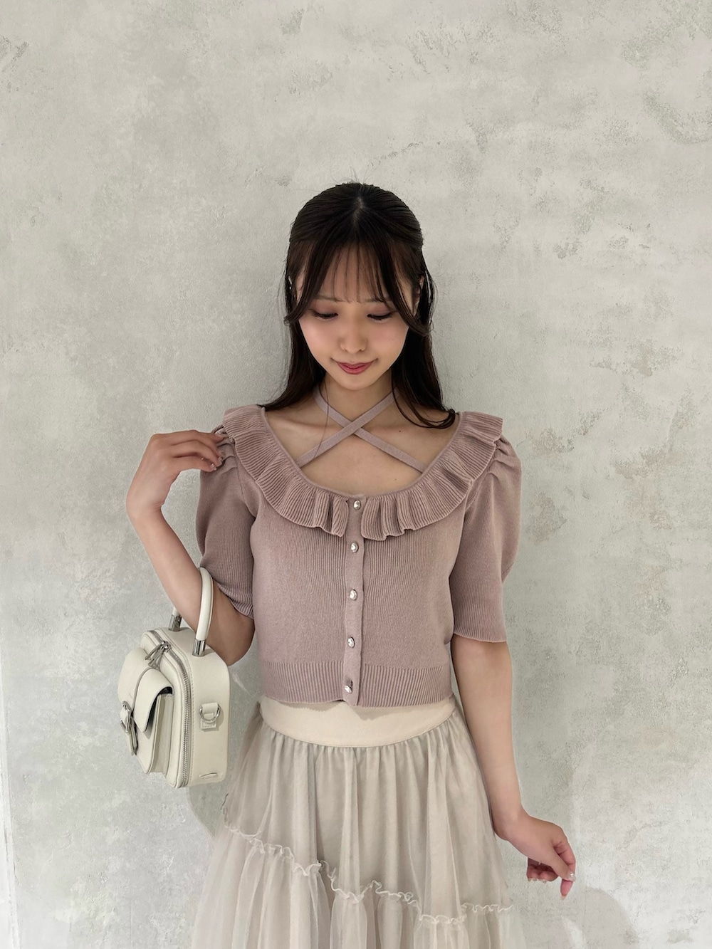 ピンク系のニット/セーター、ホワイト系のサンダル、ベージュ系のスカートを着用したレディースの夏コーディネートの3枚目の写真