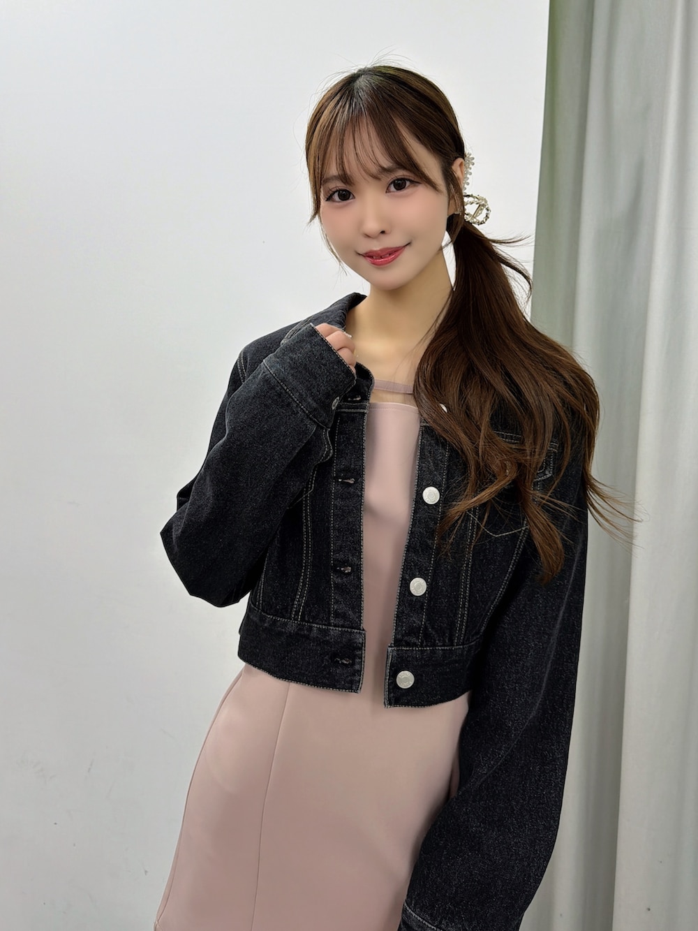 ピンク系のワンピース、ブラック系のデニムジャケット、ホワイト系のサンダルを着用したレディースの春コーディネートの6枚目の写真