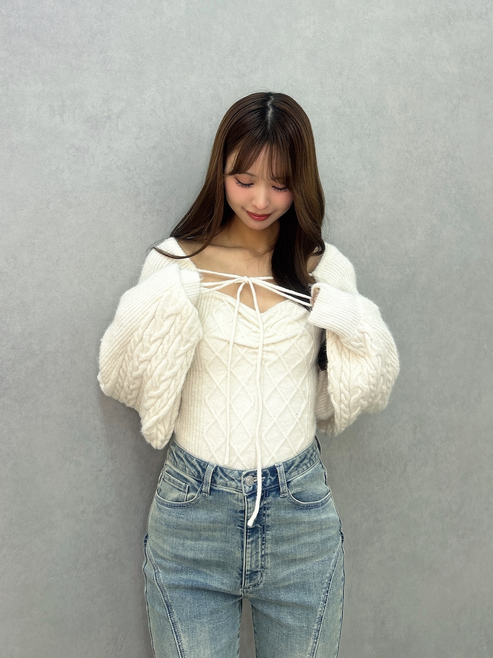 ブルー系のデニムパンツ、ホワイト系のニット/セーター、ブラック系のブーツを着用したレディースの冬コーディネートの5枚目の写真