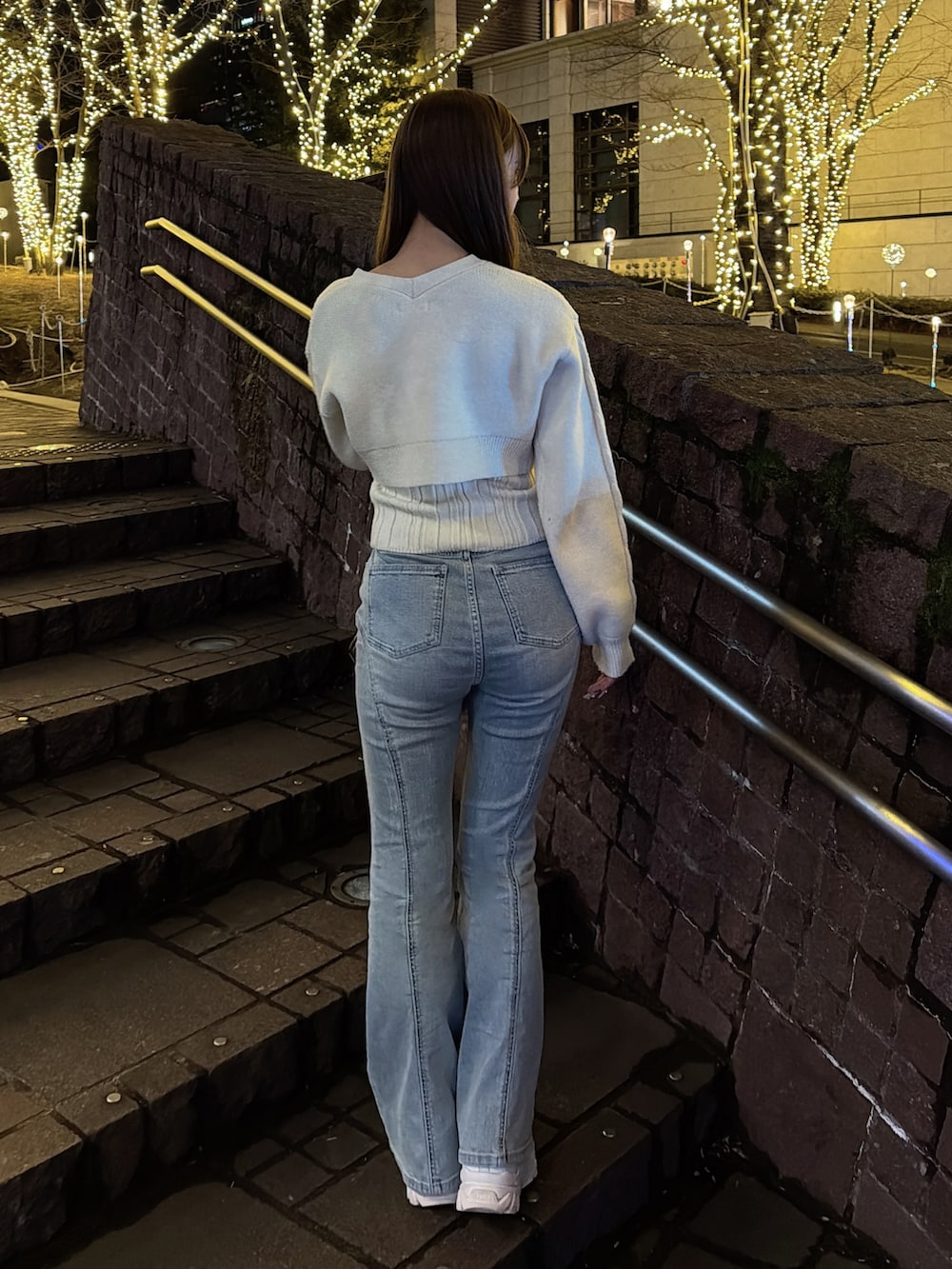 イエロー系のニット/セーター、ブルー系のデニムパンツを着用したレディースの冬コーディネートの4枚目の写真