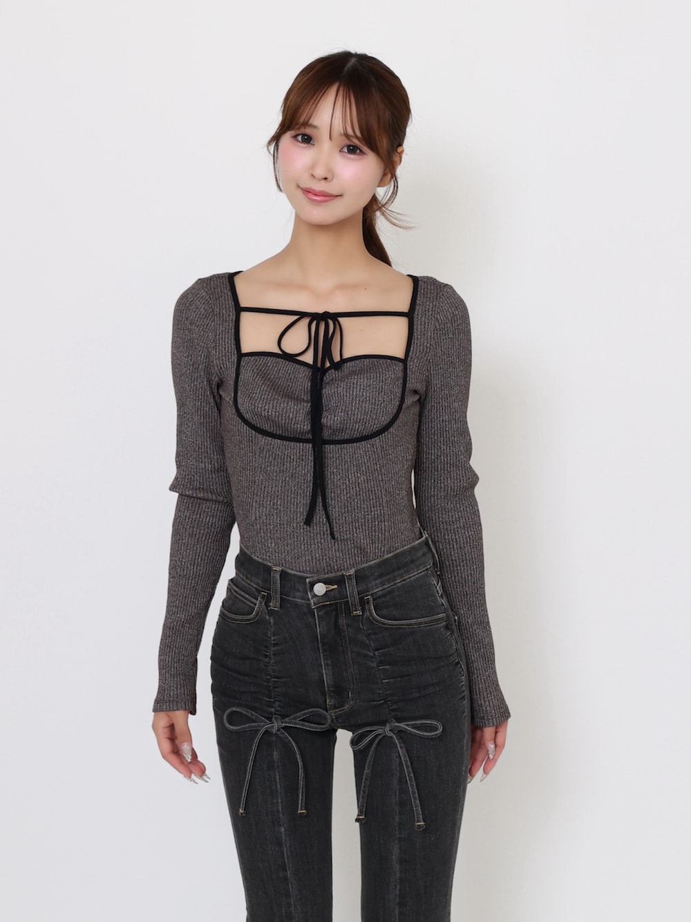 ブラック系のデニムパンツ、グレー系のTシャツ/カットソー、ブラック系のブーツを着用したレディースの夏コーディネートの6枚目の写真