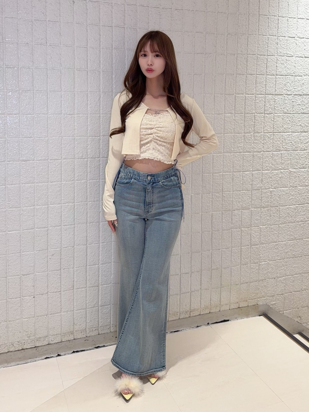 イエロー系のTシャツ/カットソー、ブルー系のデニムパンツ、イエロー系のサンダルを着用したレディースの春コーディネートの2枚目の写真