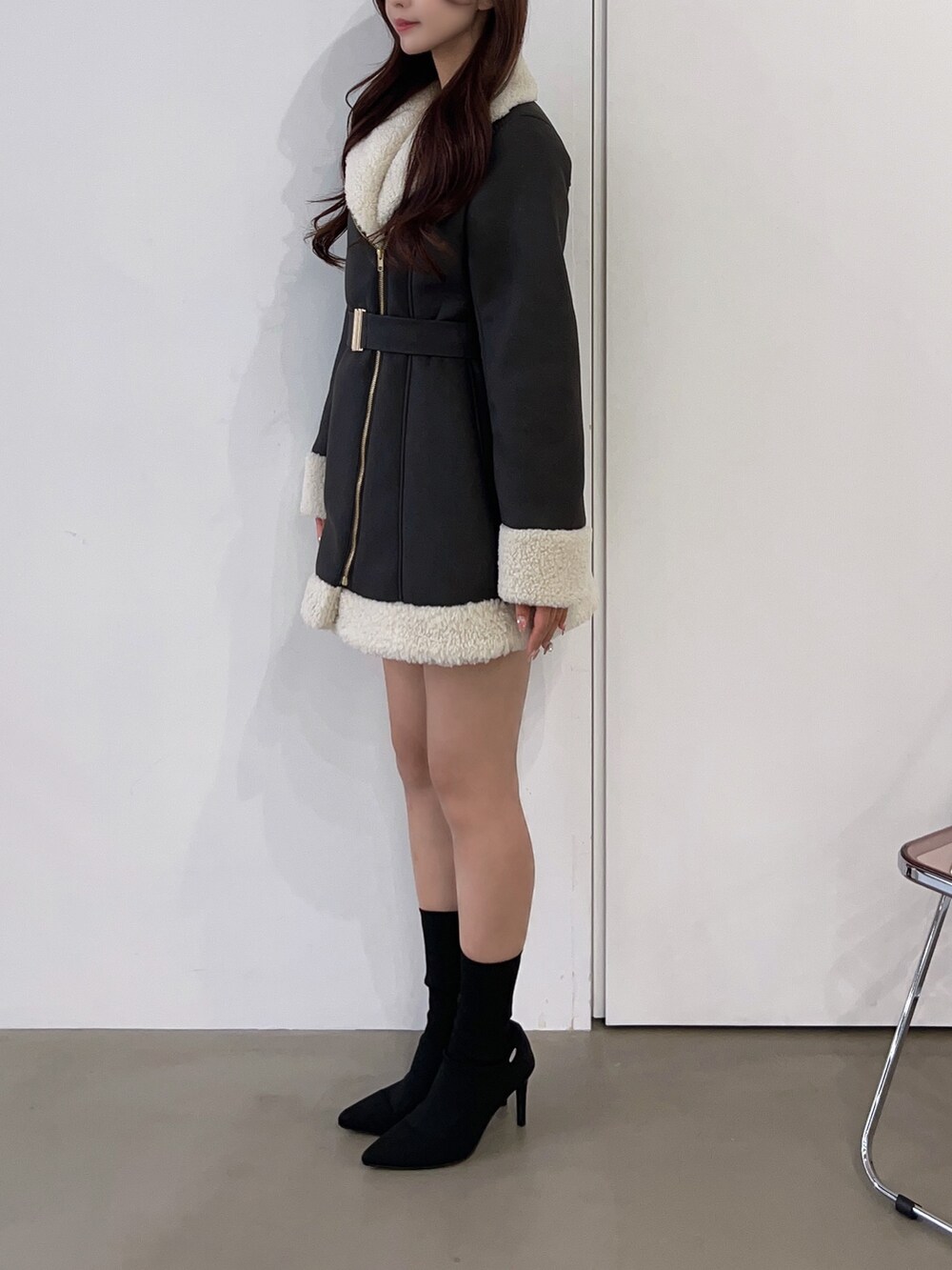 ブラウン系のムートンコート、ブラック系のブーツを着用したレディースの冬コーディネートの3枚目の写真