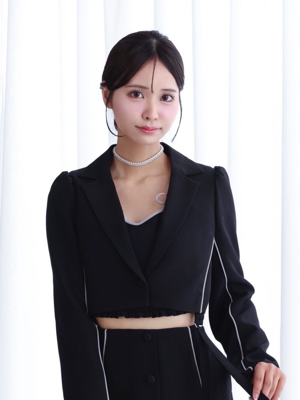 ブラック系のテーラードジャケット、ブラック系のキャミソール、ブラック系のスカートを着用したレディースの秋コーディネートの3枚目の写真