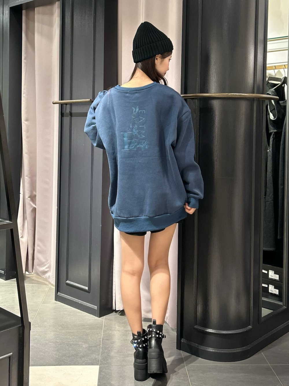 ブルー系のスウェット、ブラック系のブーツ、ブラック系のニットキャップ/ビーニーを着用したレディースの秋コーディネートの3枚目の写真