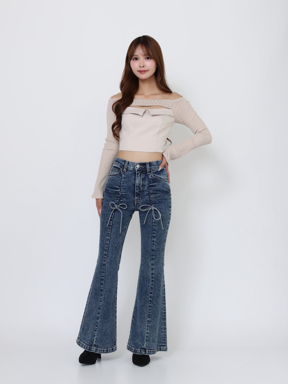 ブラック系のブーツ、ベージュ系のTシャツ/カットソー、ブルー系のデニムパンツを着用したレディースの秋コーディネートの2枚目の写真