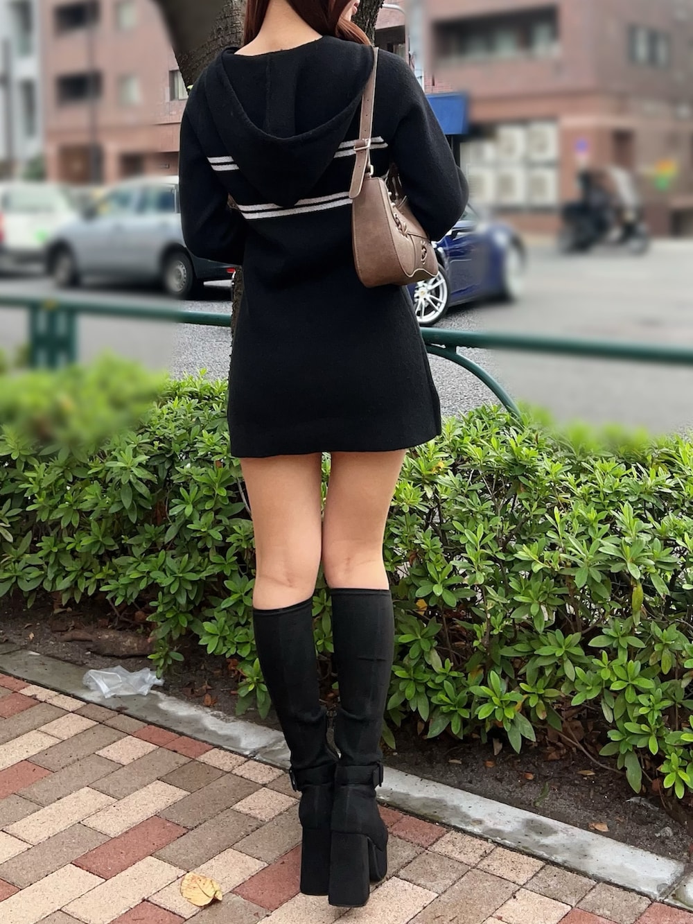 ブラック系のブーツ、ブラック系のワンピース、ブラウン系のショルダーバッグを着用したレディースの秋コーディネートの4枚目の写真