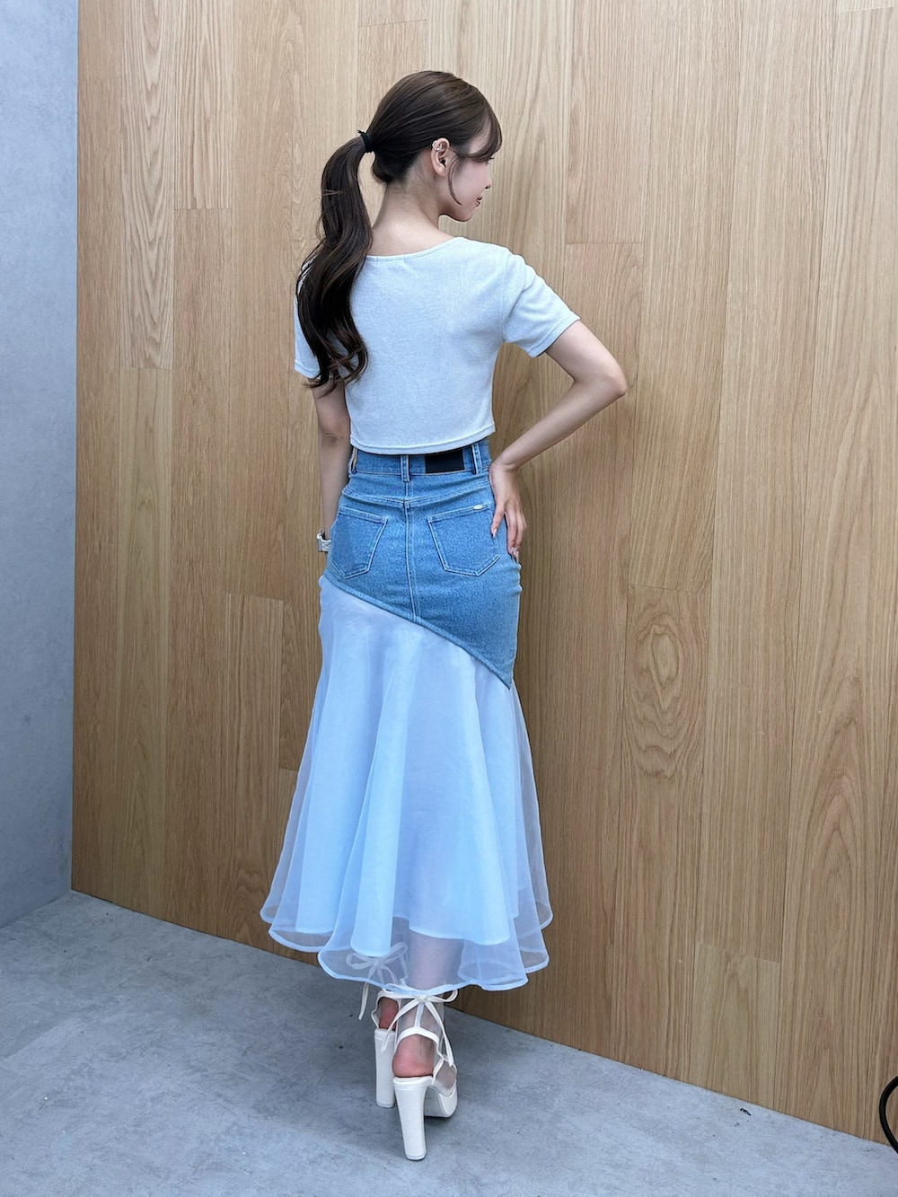 シルバー系のTシャツ/カットソー、ブルー系のデニムスカート、ホワイト系のサンダルを着用したレディースの夏コーディネートの3枚目の写真