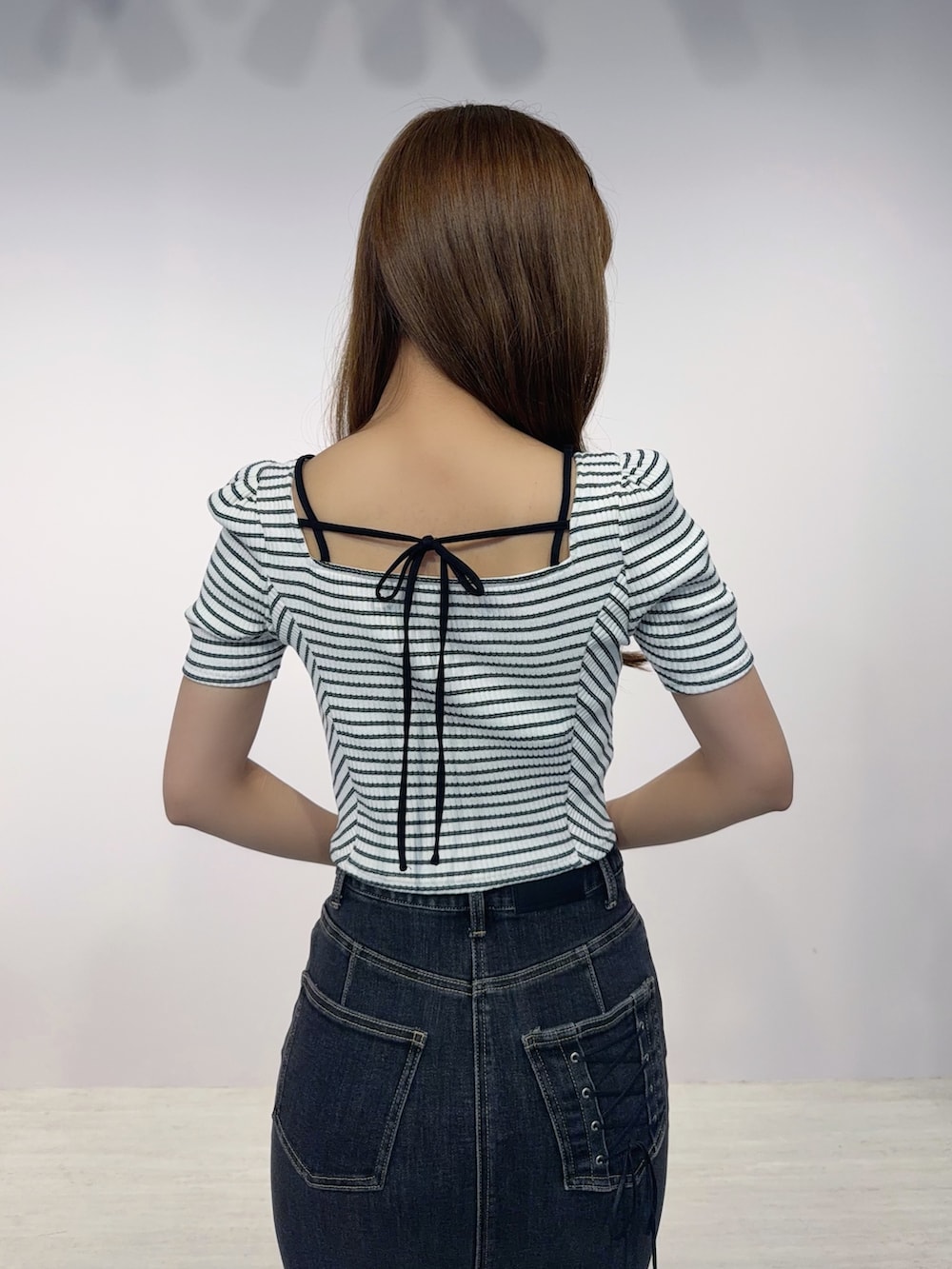ブラック系のデニムスカート、その他のTシャツ/カットソー、ブラック系のサンダルを着用したレディースの春コーディネートの5枚目の写真