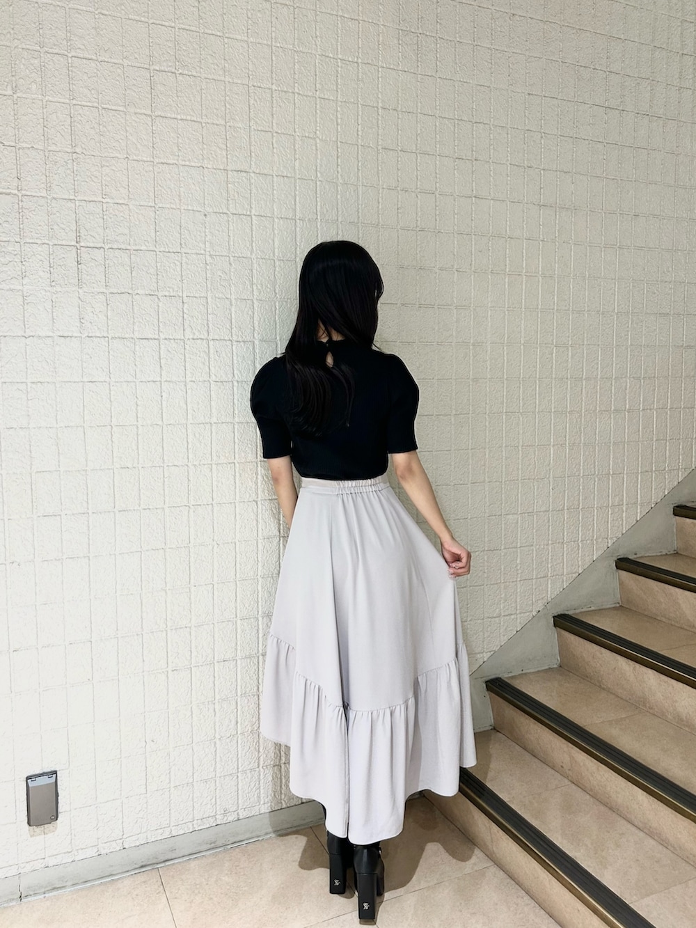 ブラック系のTシャツ/カットソー、グレー系のスカート、ブラック系のパンプスを着用したレディースの春コーディネートの4枚目の写真