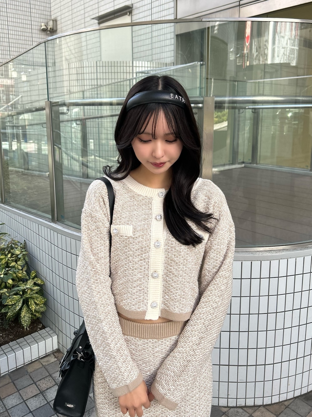 ベージュ系のスカート、ベージュ系のカーディガン/ボレロ、ブラック系のショルダーバッグを着用したレディースの冬コーディネートの3枚目の写真