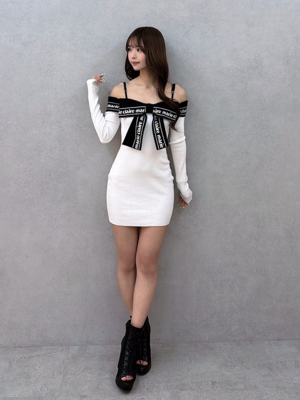 ホワイト系のワンピース、ブラック系のブーツを着用したレディースの冬コーディネートの2枚目の写真